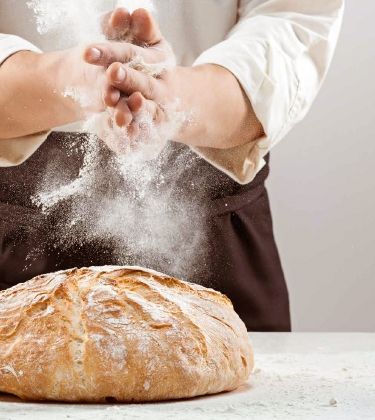 DewiBack Bäcker der gerade ein Brot zubereitet